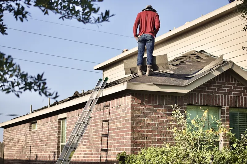 Professional roofer working on a residential roof in Grayling
